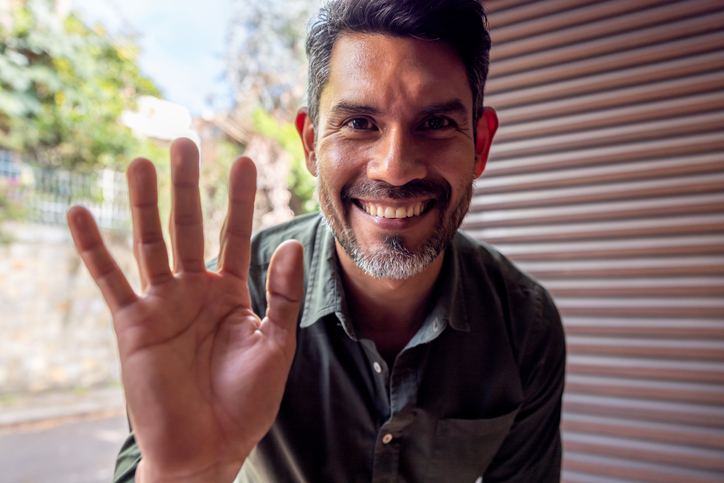 a man waves at a doorbell camera